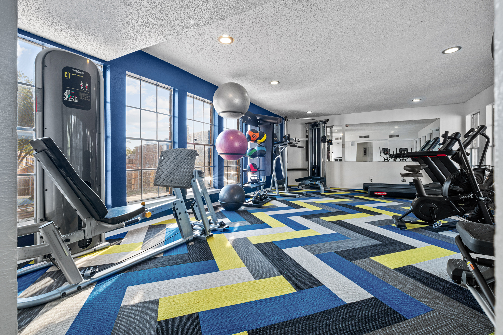 a gym room with a blue and yellow floor at The Landing at McCallum